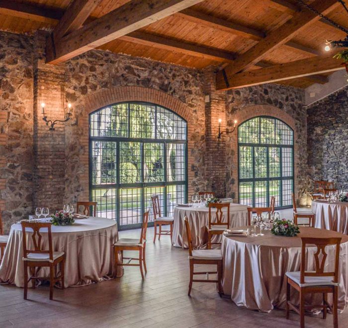 la sala con ampie vetrate e soffitto con travi di legno