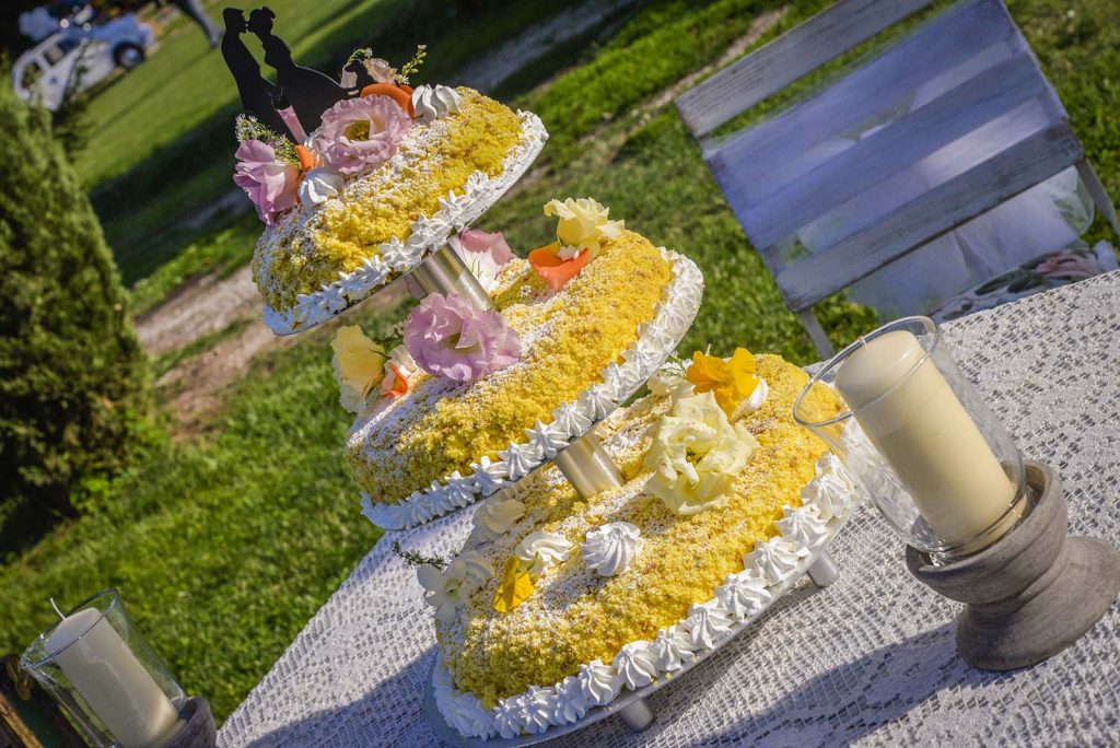 La torta mimosa con il caratteristico giallo adornato di crema bianca finemente lavorata