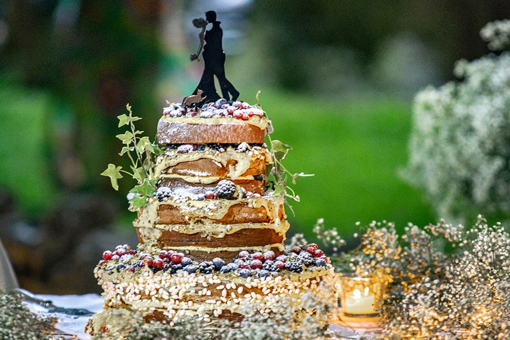 Torta nuziale con la miniatura degli sposi in cima, sopra tanta arte pasticcera